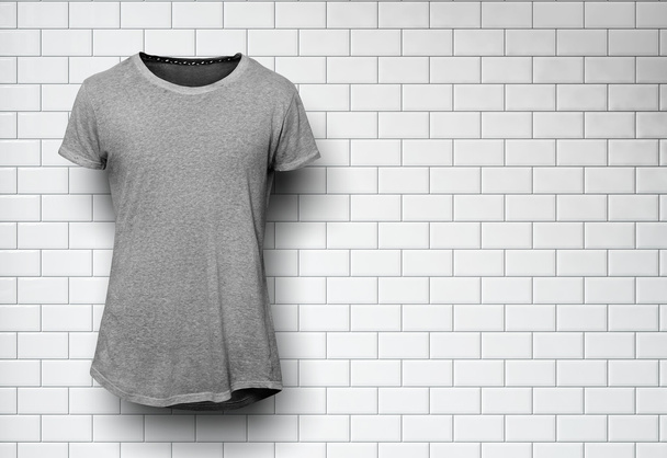 Gray tshirt isolated and wall of the bricks background - 写真・画像