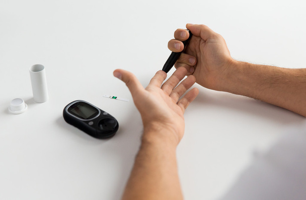 close up of man checking blood sugar by glucometer - Foto, imagen