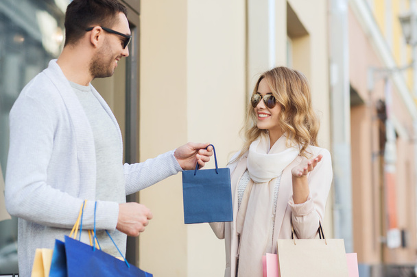happy couple with shopping bags in city - Foto, Imagem