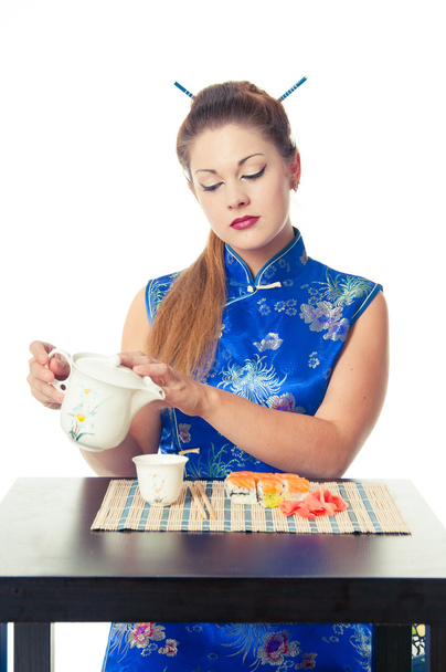 κορίτσι ρίχνει τσάι και να τρώει σούσι - Φωτογραφία, εικόνα