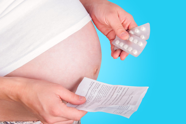 Pregnant woman holding pills. - Foto, imagen