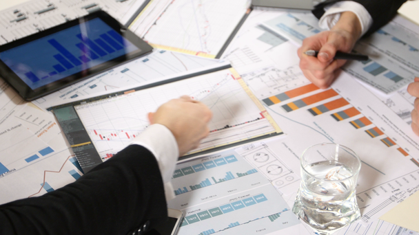 Üzleti tárgyalások: tábla grafikonokkal ellátott táblája. egy üzleti projekt fejlesztésével és a piaci adatok elemzésével kapcsolatos információelemzésen - Felvétel, videó