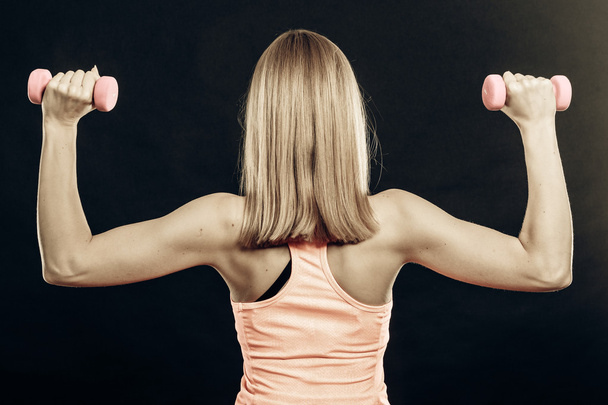 Fitness sporty girl lifting weights back view - Photo, Image