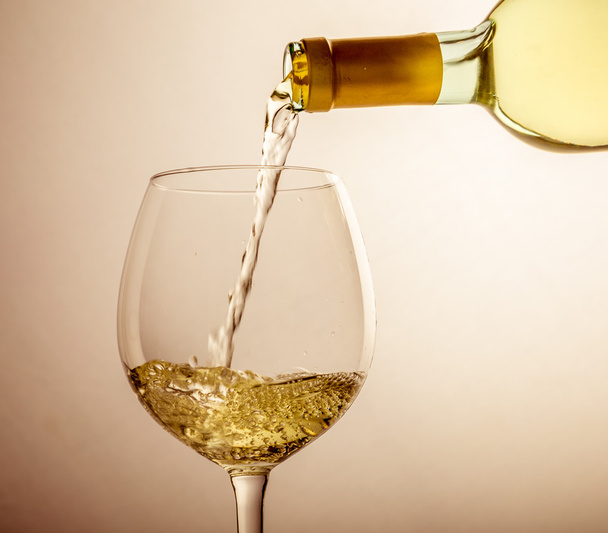 White wine pouring in glass from a bottle - Foto, Imagem