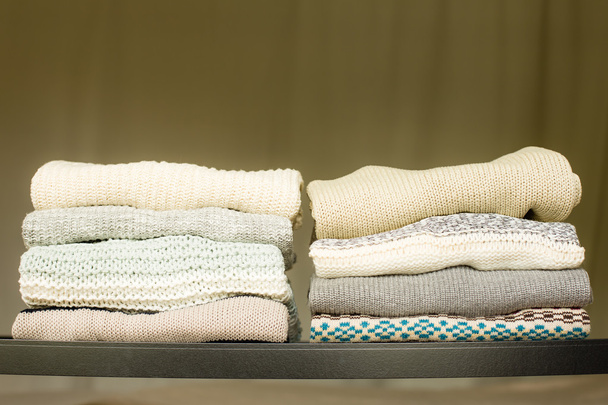 Montón de suéteres calientes en un estante
 - Foto, imagen