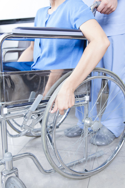 sairaanhoitaja auttaa nainen pyörätuolissa
 - Valokuva, kuva