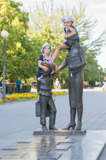 Дві дівчини на пам'ятнику першому вчителю
 - Фото, зображення