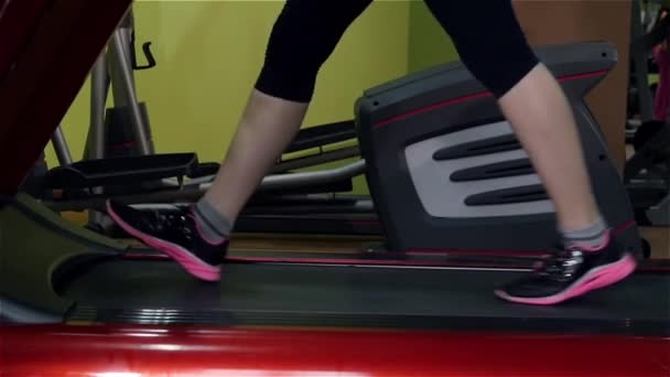 Attaractive lány csinál egy edzés a fitness nyomon az edzőteremben, lassú mozgás - Felvétel, videó