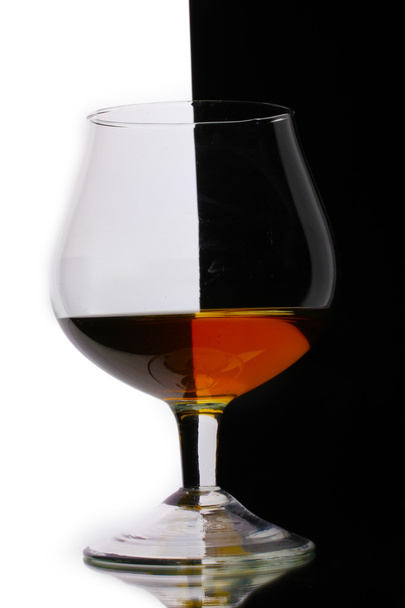 Glass of cognac on white-black background - Photo, Image