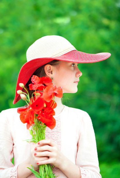 Jovem bela senhora / menina em chapéu vermelho com flores de papoula buquê
. - Foto, Imagem