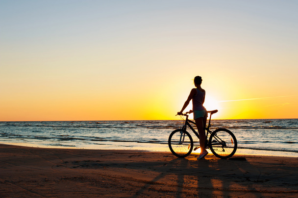 Moment in Zeit. sportliche Radlerin-Silhouette auf buntem - Foto, Bild