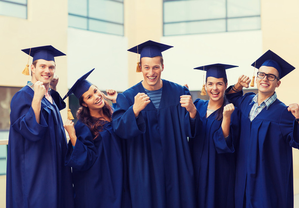 group of smiling students in mortarboards - Фото, изображение