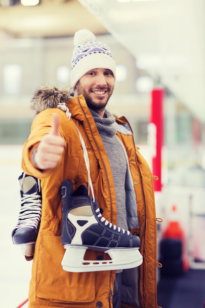 happy young man showing thumbs up on skating rink - 写真・画像