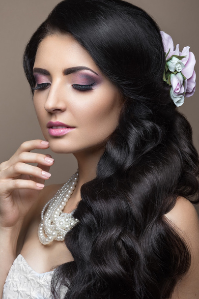 Beautiful brunette woman in image of the bride with flowers. Beauty face and Hairstyle - Fotó, kép