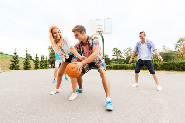 group of happy teenagers playing basketball - Foto, afbeelding