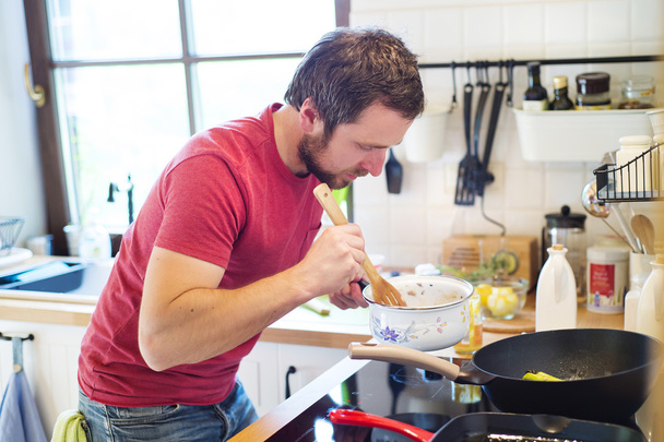 Hombre preparando salsa cremosa de champiñones
 - Foto, imagen