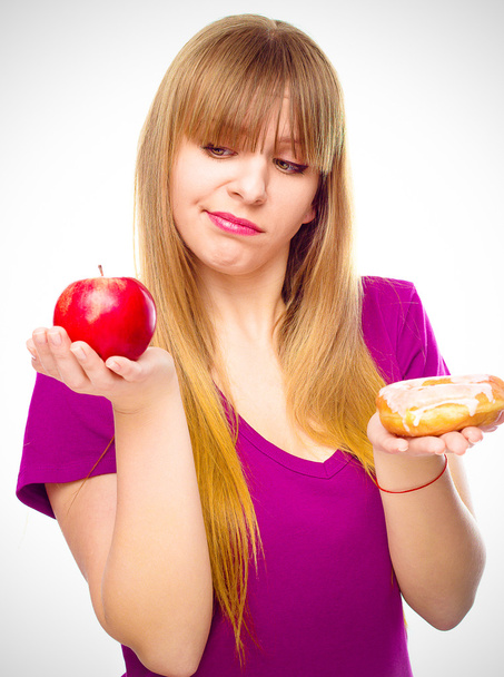 Kobieta, wybierając między owoce i słodycze - Zdjęcie, obraz