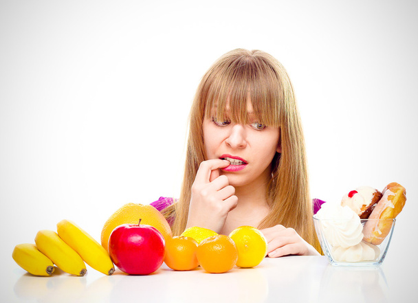 Жінка вибирає між фруктами і цукерками
 - Фото, зображення