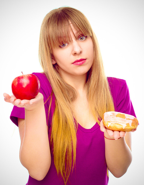 Nainen valita hedelmien ja makeisten välillä
 - Valokuva, kuva