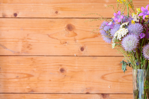 Fioletowe kwiaty na tle desek - Zdjęcie, obraz