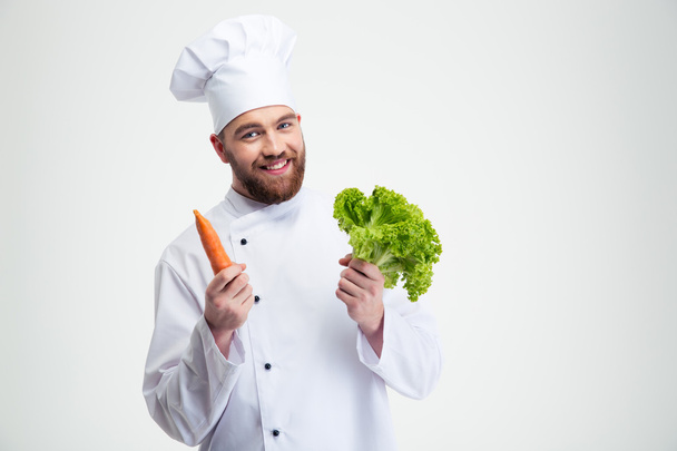 Chef cook holding salad and carrot - Photo, image