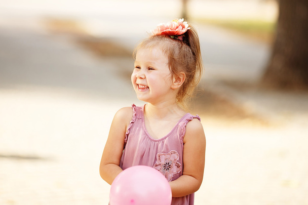 Portret van lachen en spelen een meisje houdt van een ballon - Foto, afbeelding