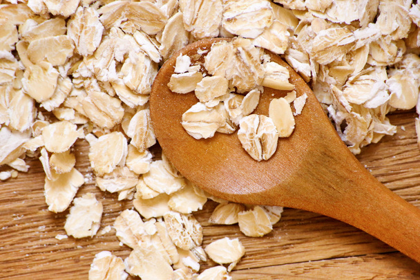 Rolled oats and oat ears of grain on a wooden table - Foto, imagen