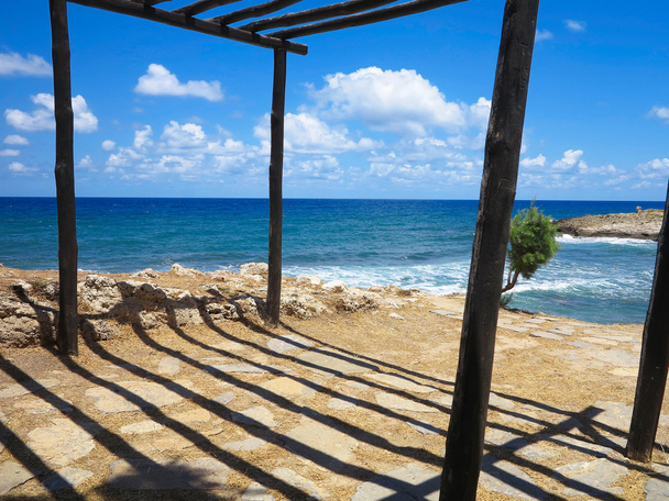 Staré dřevěné kabiny na mořské pobřeží a modrá obloha - Fotografie, Obrázek
