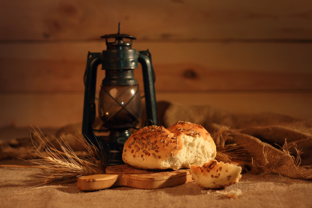Fresh loaf of homemade bread on a background of a lantern. - Foto, immagini