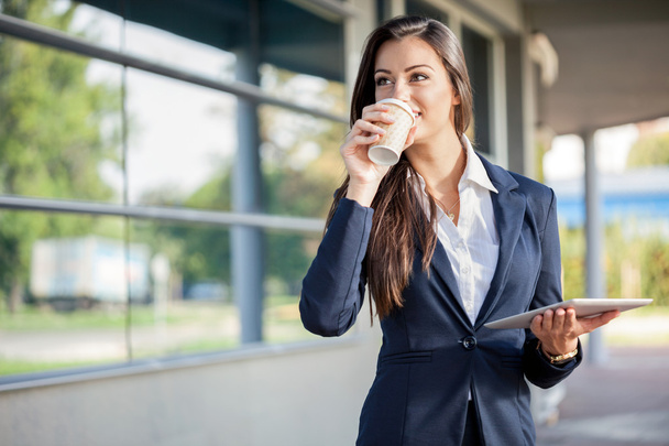 Businesswoman outside with coffee and tablet - Photo, Image