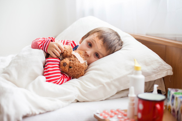 Sick child boy lying in bed with a fever, resting - Foto, Bild