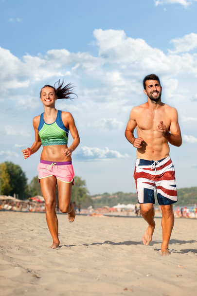 Young couple running on beach - Фото, зображення