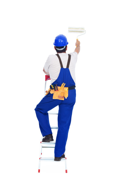Handyman or worker painting with roller brush on a ladder - Φωτογραφία, εικόνα