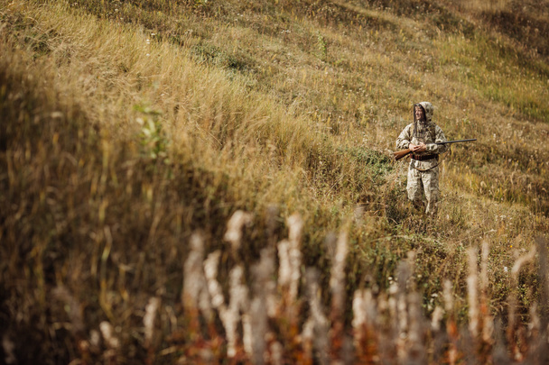 man hunter with shotgun in forest - Fotó, kép