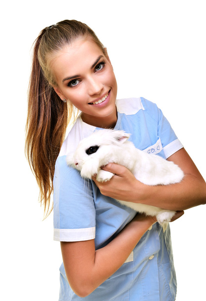 Smiling vet holding up and examining cute white rabbit - Фото, зображення
