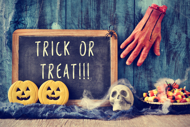 chalkboard with the text trick or treat in a halloween scene - 写真・画像