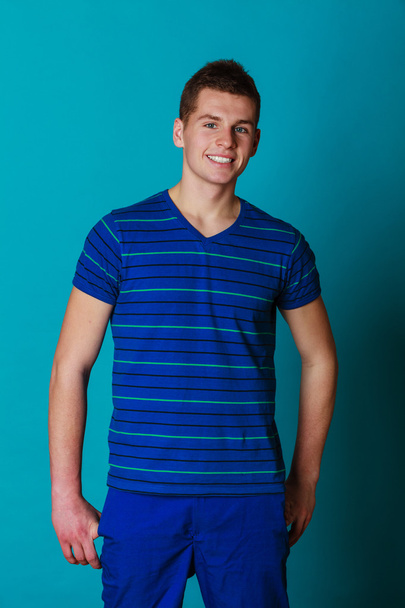 Young smiling man portrait on blue - Foto, afbeelding