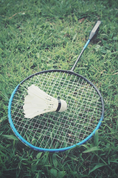 Shuttles met badminton racket op groen gras - Foto, afbeelding