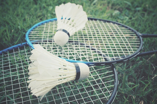 Shuttlecocks with badminton racket on green grass - Photo, Image
