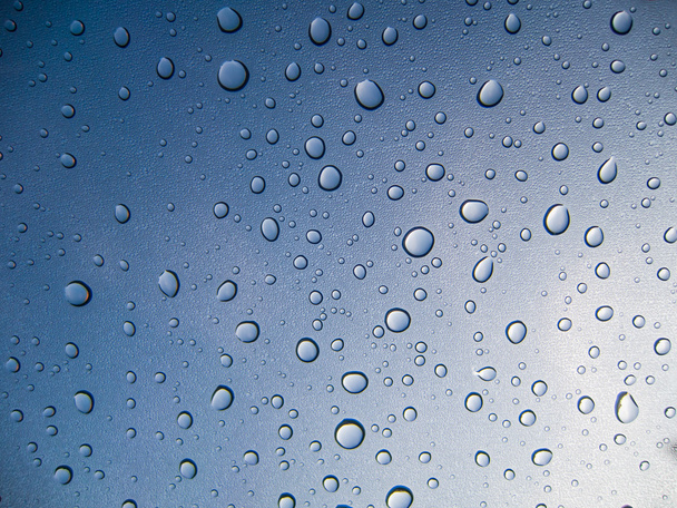 Water drops on glass on blue background - Photo, Image