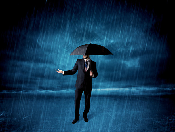 Biznesmen stojący w deszczu z parasolem - Zdjęcie, obraz