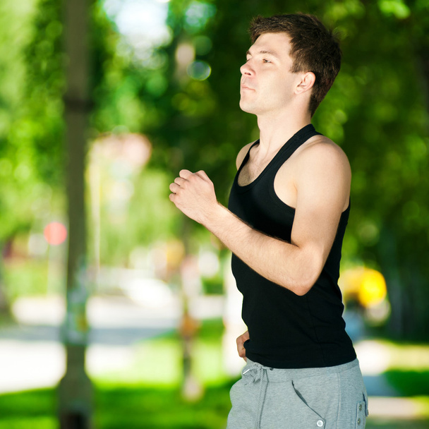 jonge man joggen in het park - Foto, afbeelding