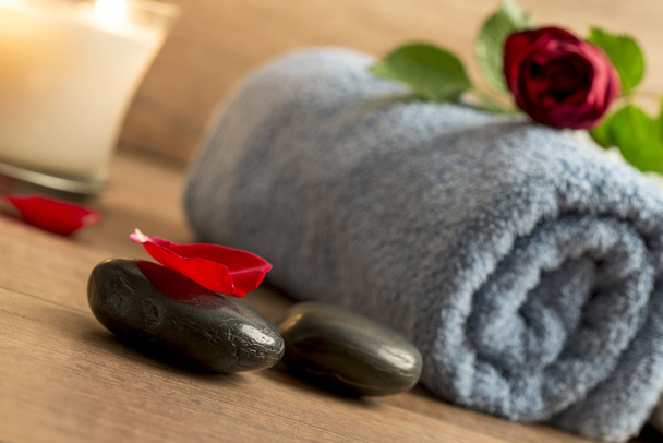 Ambiente romántico con una rosa roja sobre una toalla enrollada, iluminada
 - Foto, Imagen