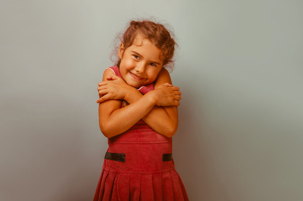 Девчонка из Европы десятилетие обнимает себя на синем фоне
 - Фото, изображение