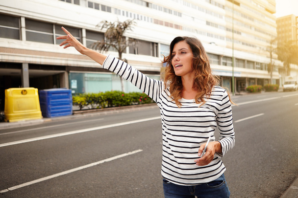 Young caucasian woman hailing a cab - Foto, afbeelding