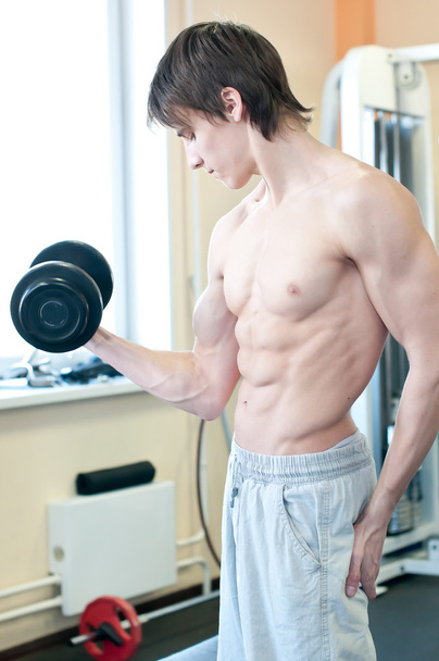 Powerful muscular man lifting weights in gym - Fotoğraf, Görsel