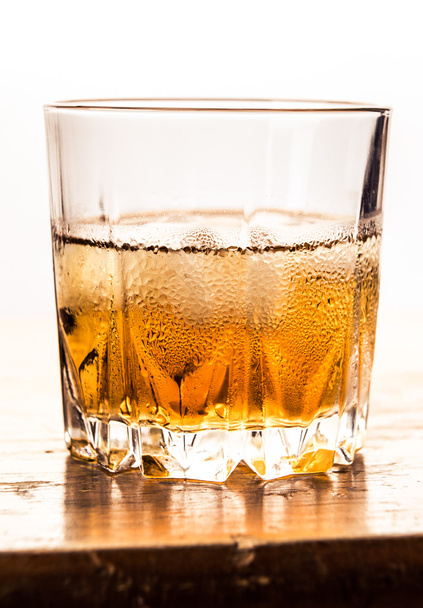 Glass of cold whiskey on wooden surface - Fotografie, Obrázek