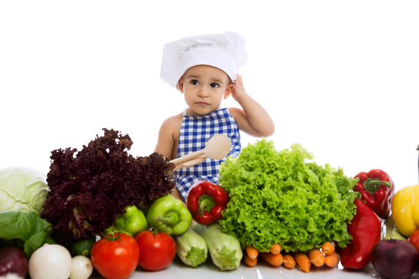 Little boy in chef's hat with scoop and cooking vegetables - Фото, изображение