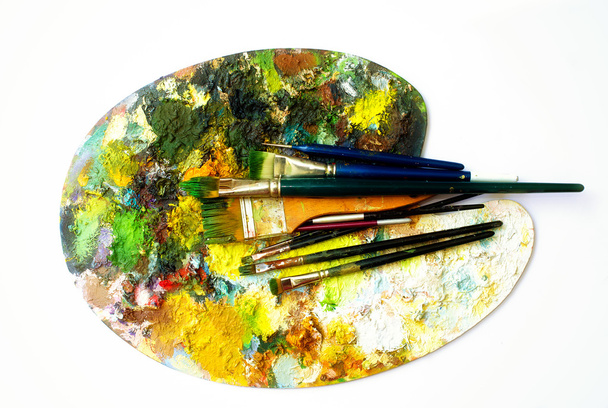 Paint brushes to the painting palette with colors on a white background - Photo, Image