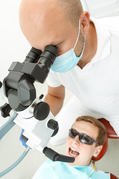 Dentist using dental microscope during inspection - Zdjęcie, obraz